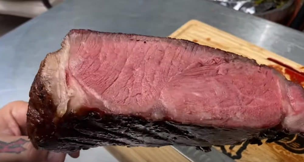a cut into medium rare smoked tomahawk steak