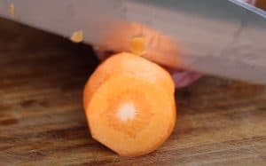 slicing a carrot with a knife