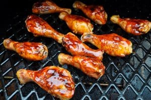 smoked chicken legs on a pit boss pellet grill with barbecue sauce