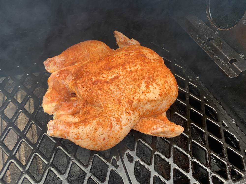 a whole chicken smoking on a pit boss pellet grill