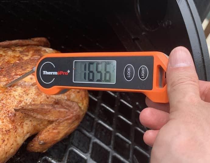 an internal temperature probe showing 165 degrees on a pit boss smoked whole chicken