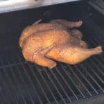 a whole chicken smoking on a pit boss pellet grill