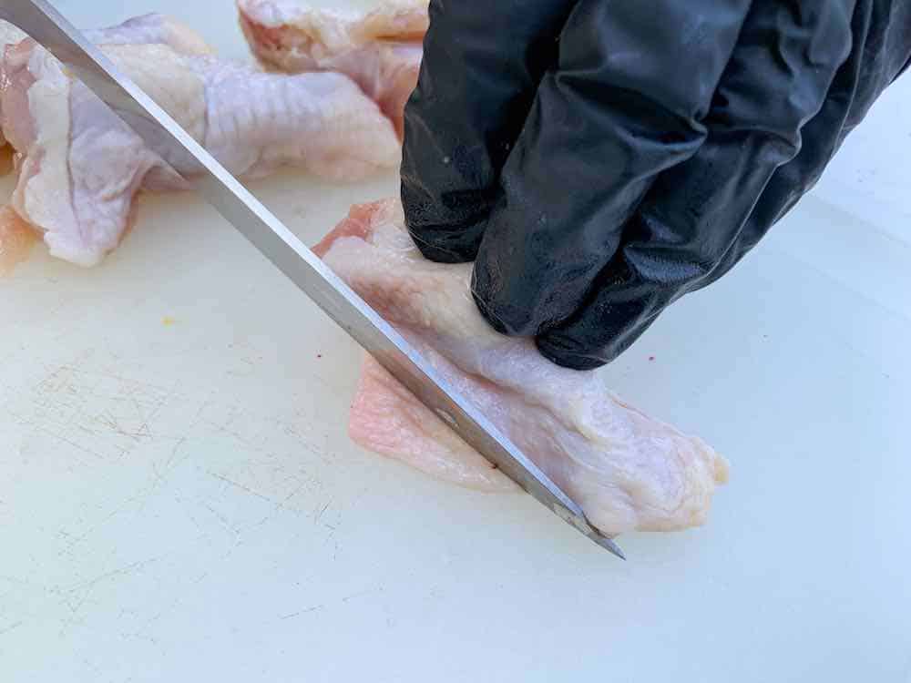 trimming a chicken wing of excess fat