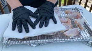 patting chicken wings dry with paper towels