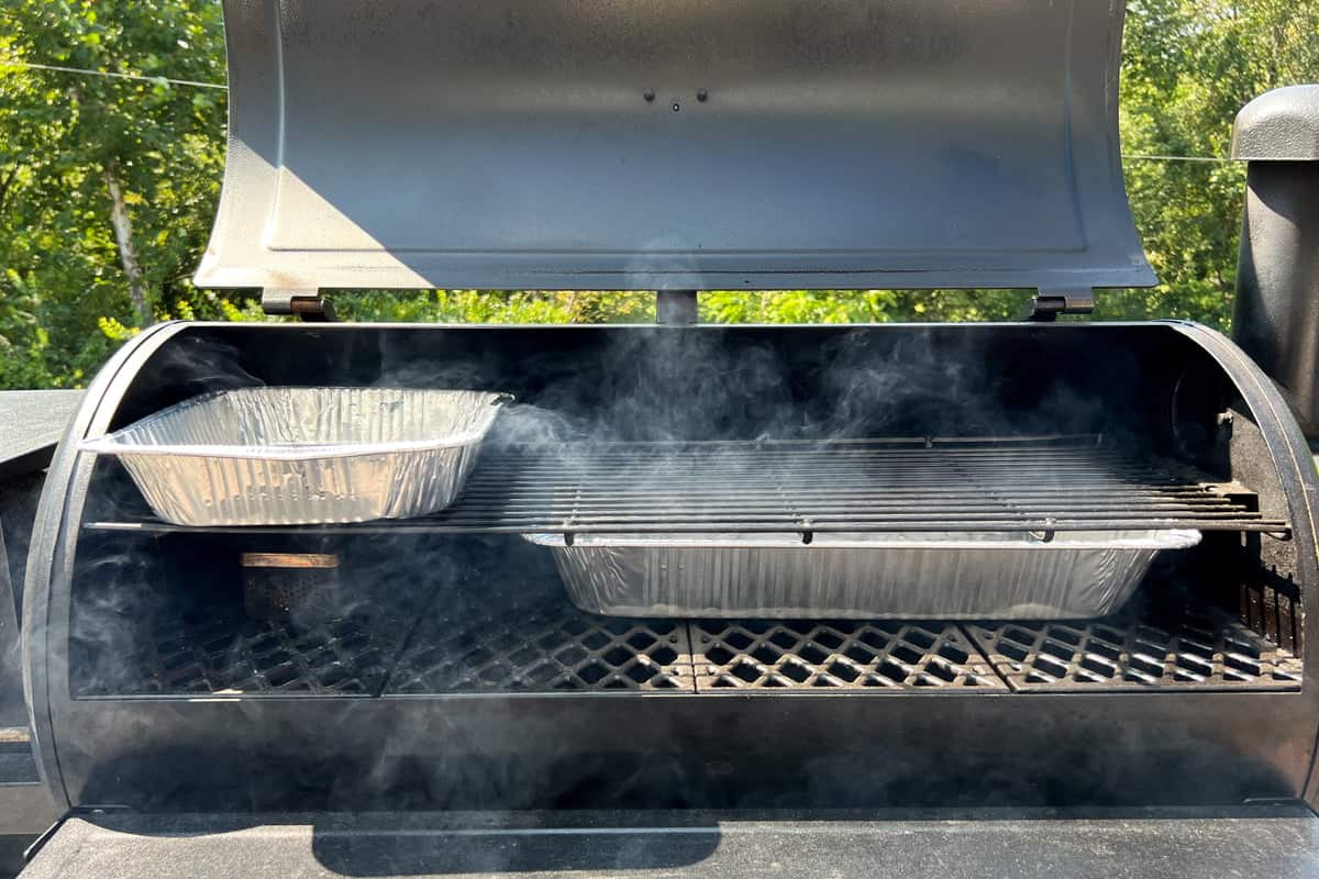 pit boss with large ice water pan on lower shelf, small ice water pan on upper shelf, and a smoke box on the lower rack by the temperature probe