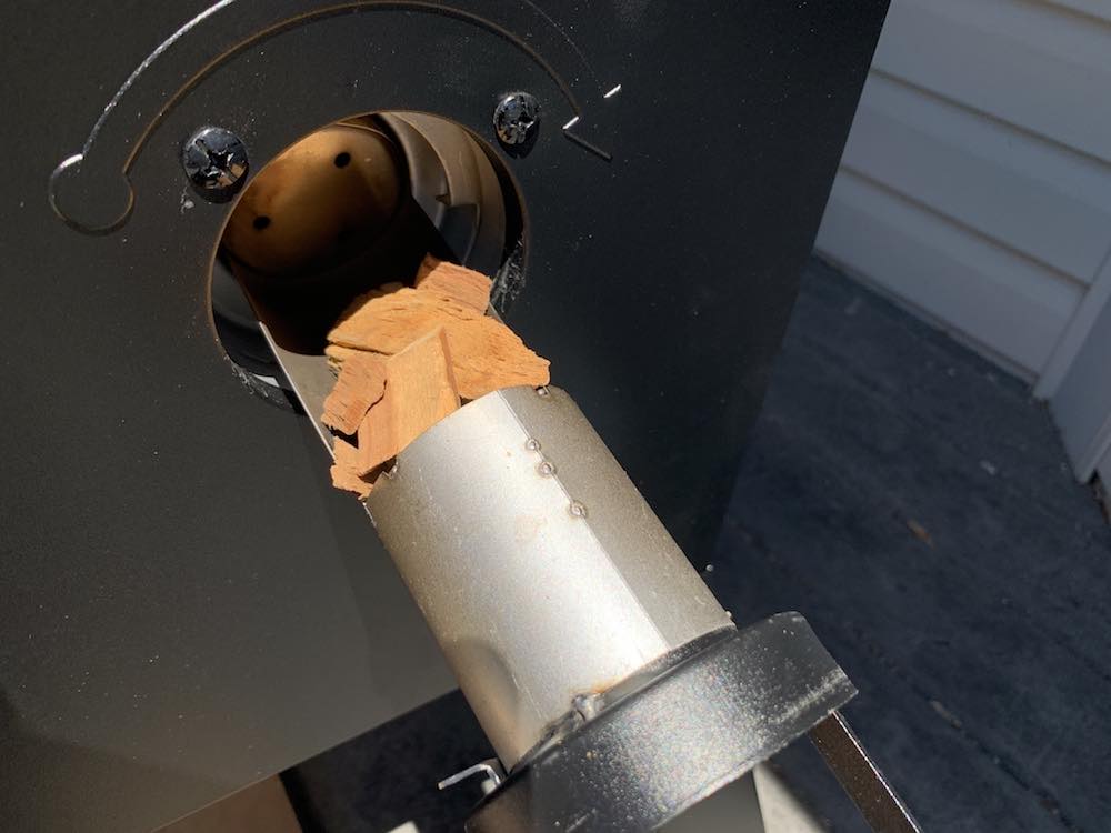 wood chips being loaded into a masterbuilt electric smoker