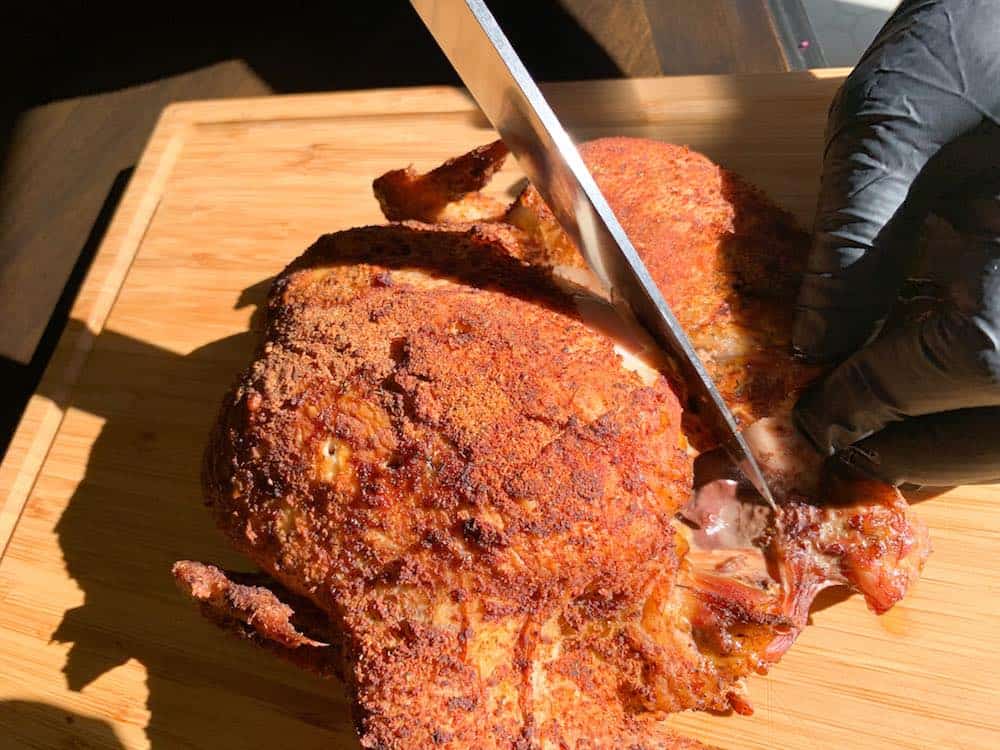 carving a smoked whole chicken