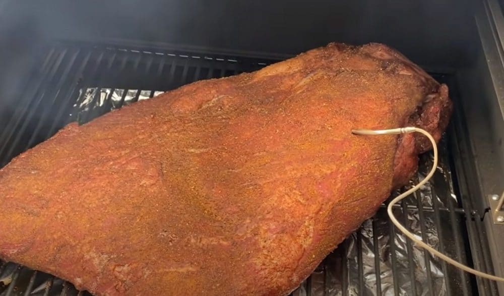 a beef brisket placed on a camp chef pellet grill