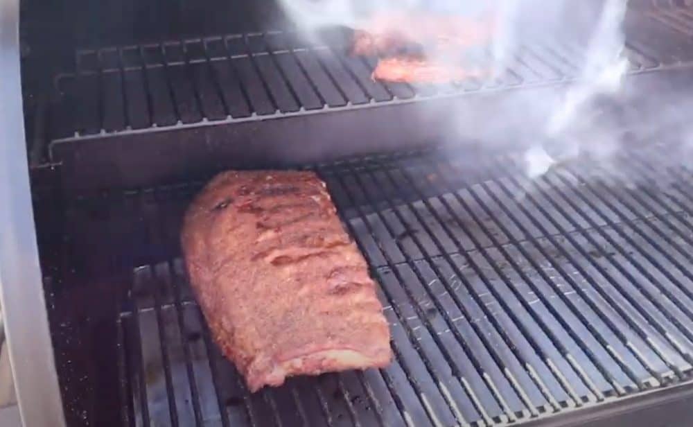putting a rack of pork spare ribs on a traeger pellet grill
