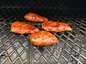 chicken breasts smoking on a traeger pellet grill