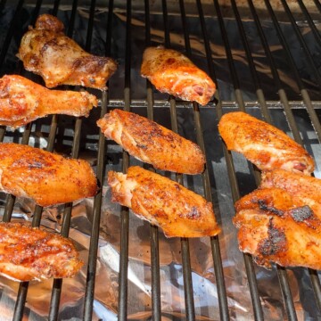 smoked chicken wings on the grates of a Traeger pellet grill