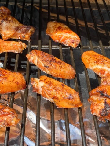 smoked chicken wings on the grates of a Traeger pellet grill