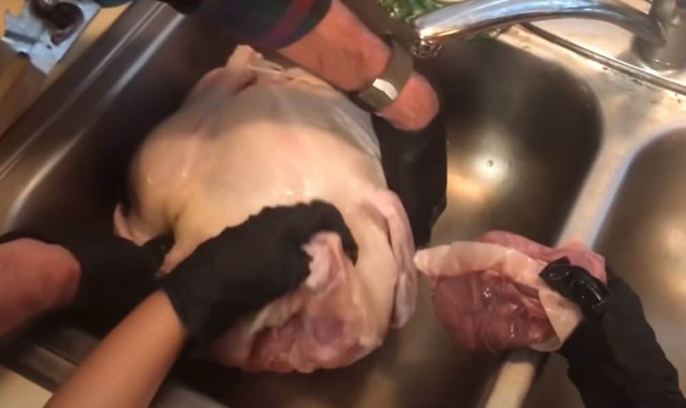 removing the giblet bag from a raw turkey