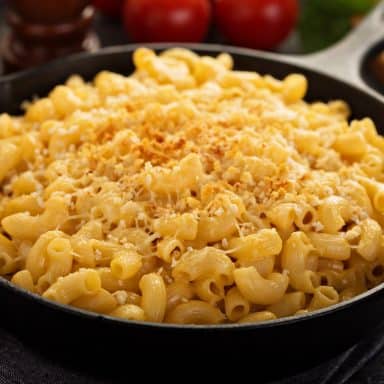 smoked mac and cheese in a cast iron skillet cooked on a pit boss pellet grill