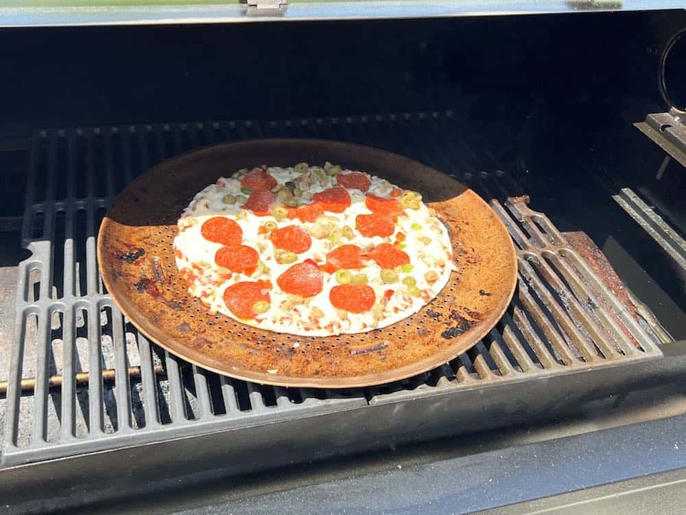 a frozen pizza on a pellet grill