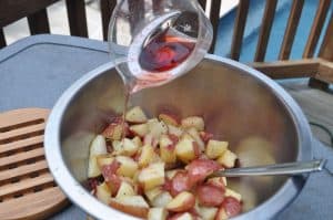 pouring red wine vinegar onto potatoes