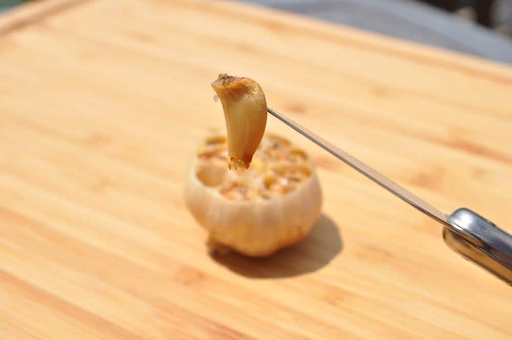 a clove of smoked garlic on a knife