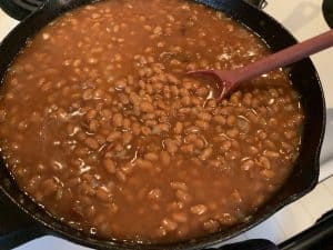 stirring baked beans before smoking