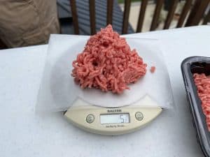 5 ounces hamburger meat on a kitchen scale