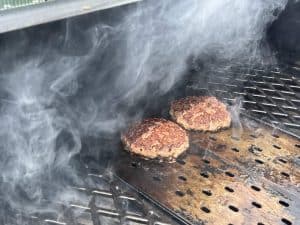 hamburgers searing on grill grates on a pit boss pellet grill