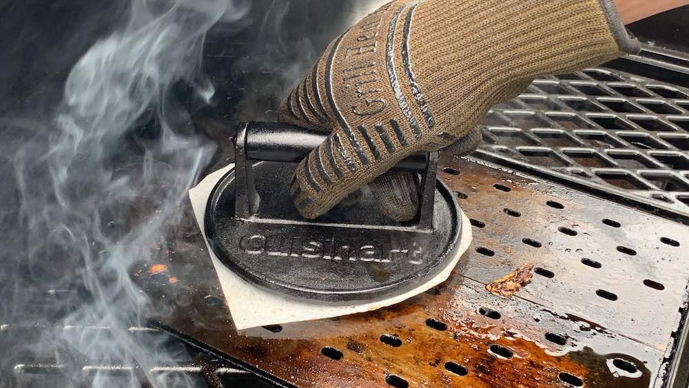 Cuisinart burger press smashing ground beef down onto a grill grate