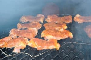 boneless skinless chicken thighs smoking on a pellet grill