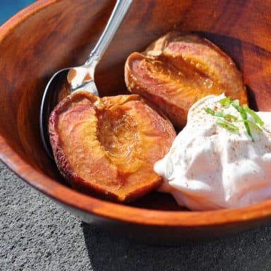 smoked peaches in a bowl with whipped cream