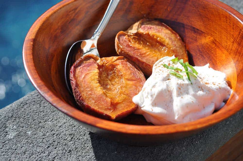 smoked peaches in a bowl with whipped cream