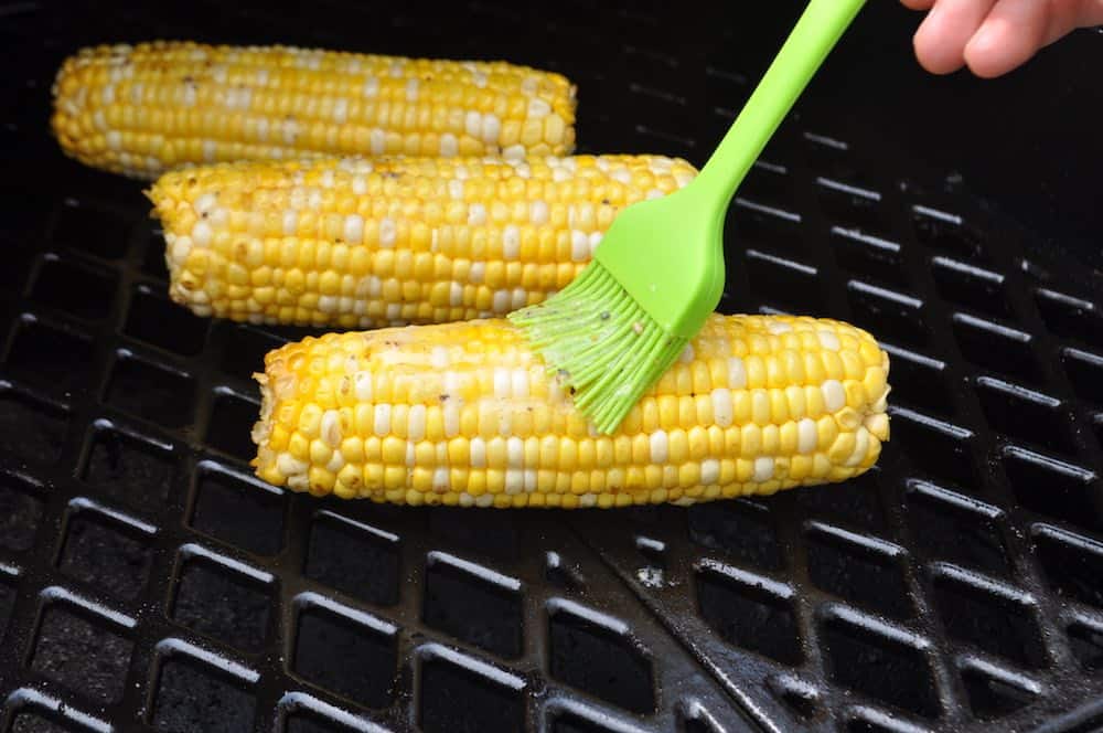 basting more seasoned butter on pit boss smoked corn on the cob