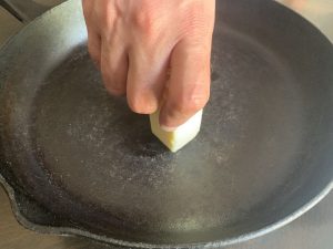 rubbing butter on a cast iron skillet