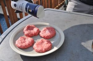 sprinkling kosher salt on raw hamburger patties