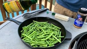 drizzling olive oil on green beans