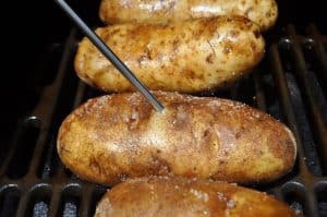 a temperature probe in a smoked baked potato