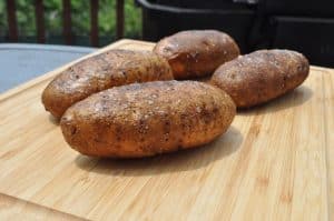 smoked baked potatoes on a cutting board