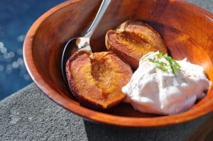 smoked peaches in a bowl with whipped cream