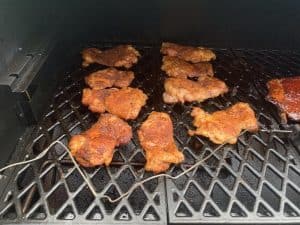 boneless skinless chicken thighs smoking on a pellet grill