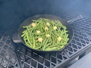 putting green beans in a smoker to smoke