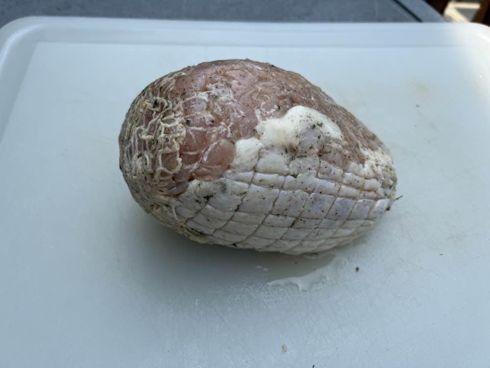 a raw boneless turkey breast on a cutting board