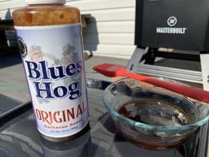 blues hog barbecue sauce in front of a masterbuilt electric smoker