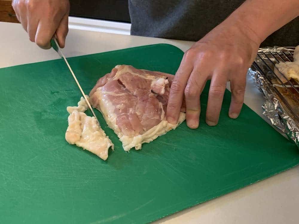 trimming the skin on raw chicken thighs