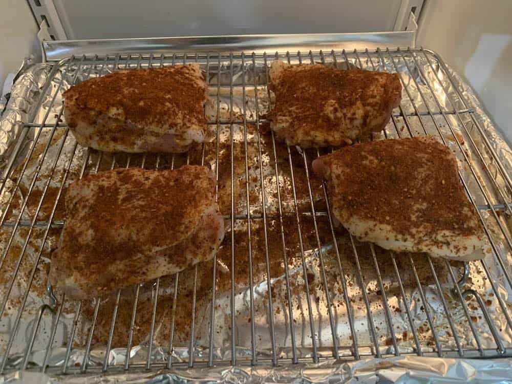 chicken thighs dry brining in a refrigerator before smoking