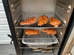 chicken breasts smoking in a masterbuilt electric smoker