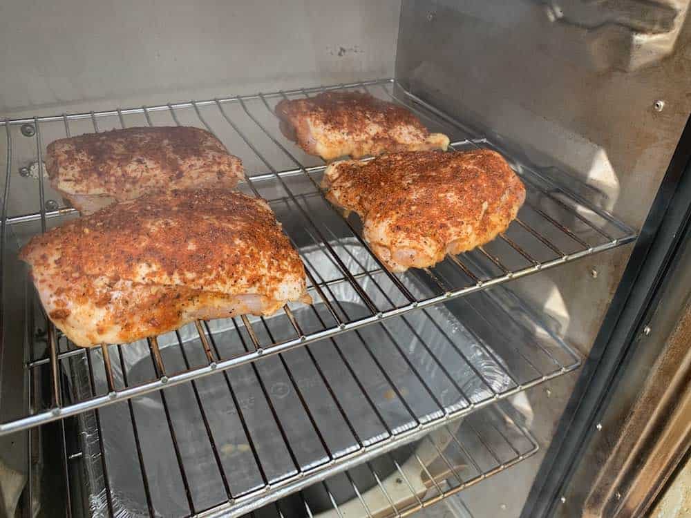 chicken thighs smoking in a masterbuilt electric smoker