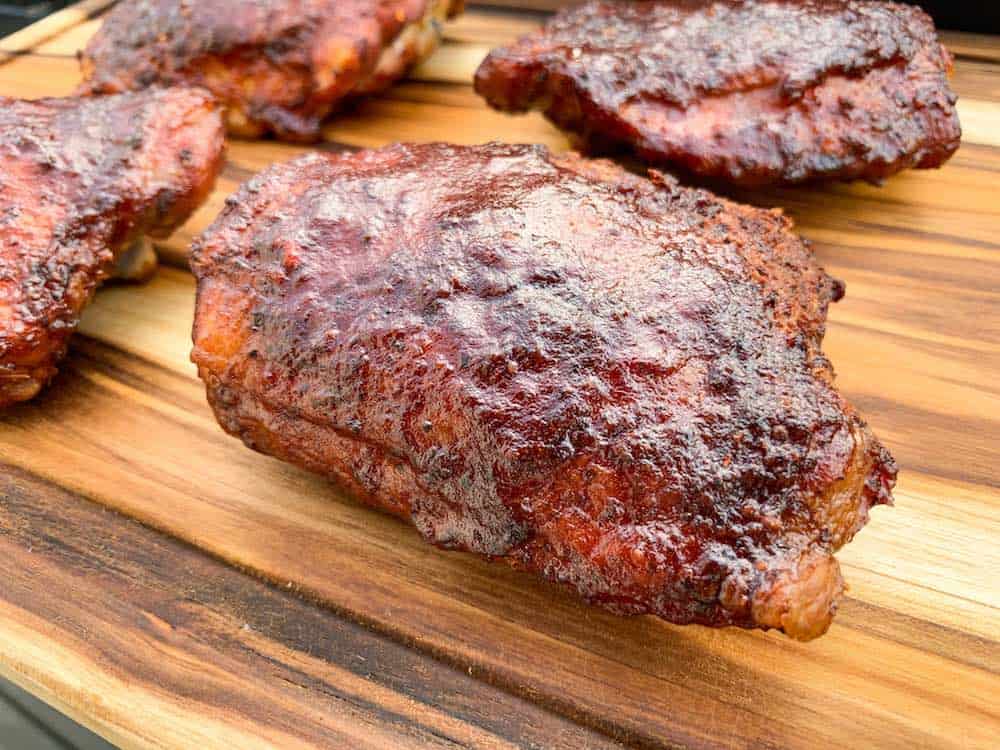 electric smoker smoked chicken thighs on a cutting board