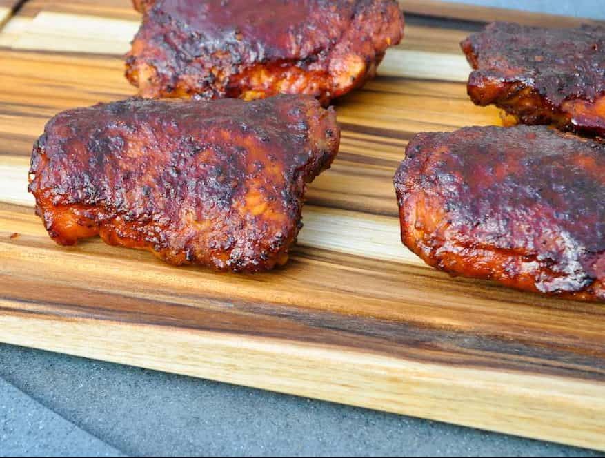 electric smoker smoked chicken thighs on a cutting board