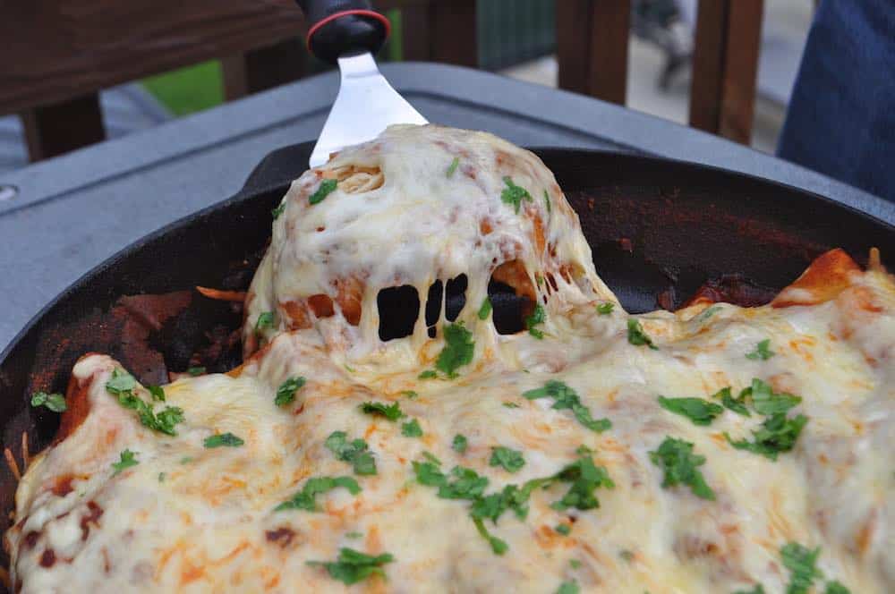 pulling out a smoked chicken enchilada with a spatula