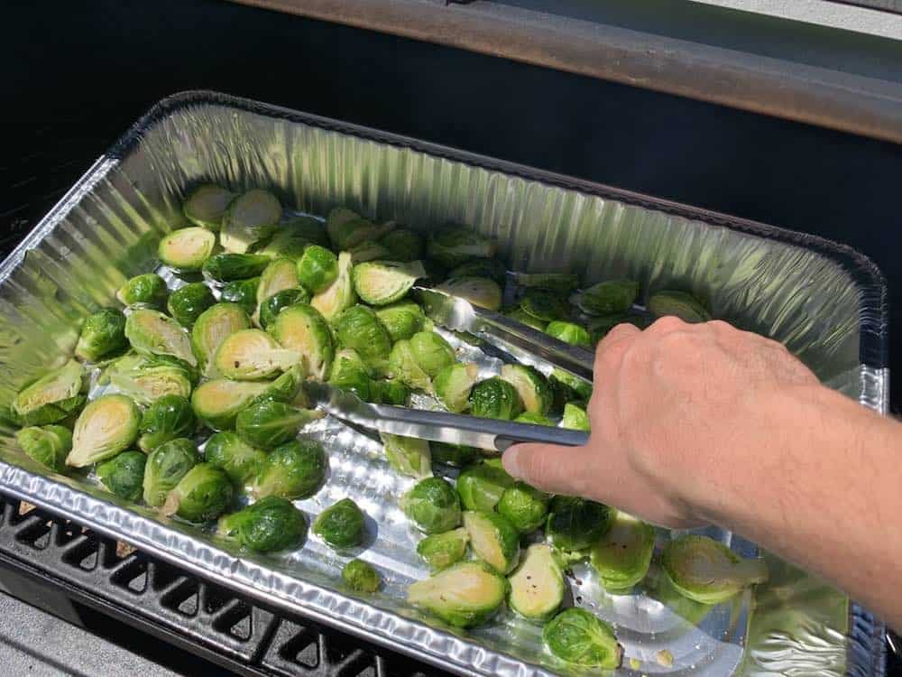 tossing smoked brussel sprouts as they cook with tongs
