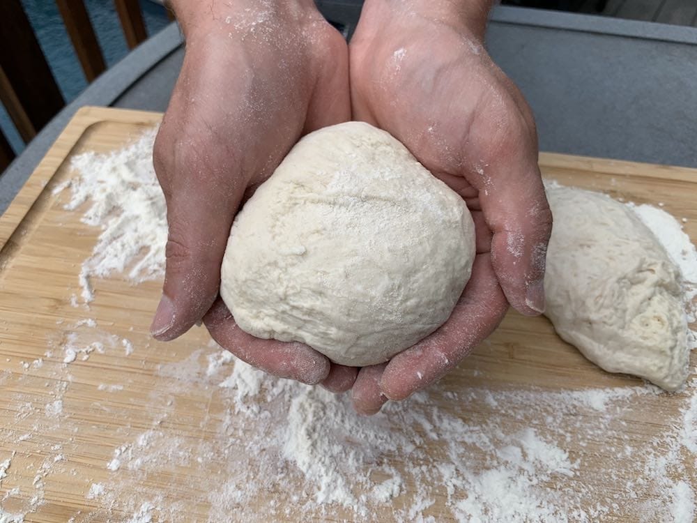 a ball of pizza dough in hands