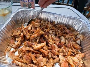 stirring sauce into smoked pulled chicken