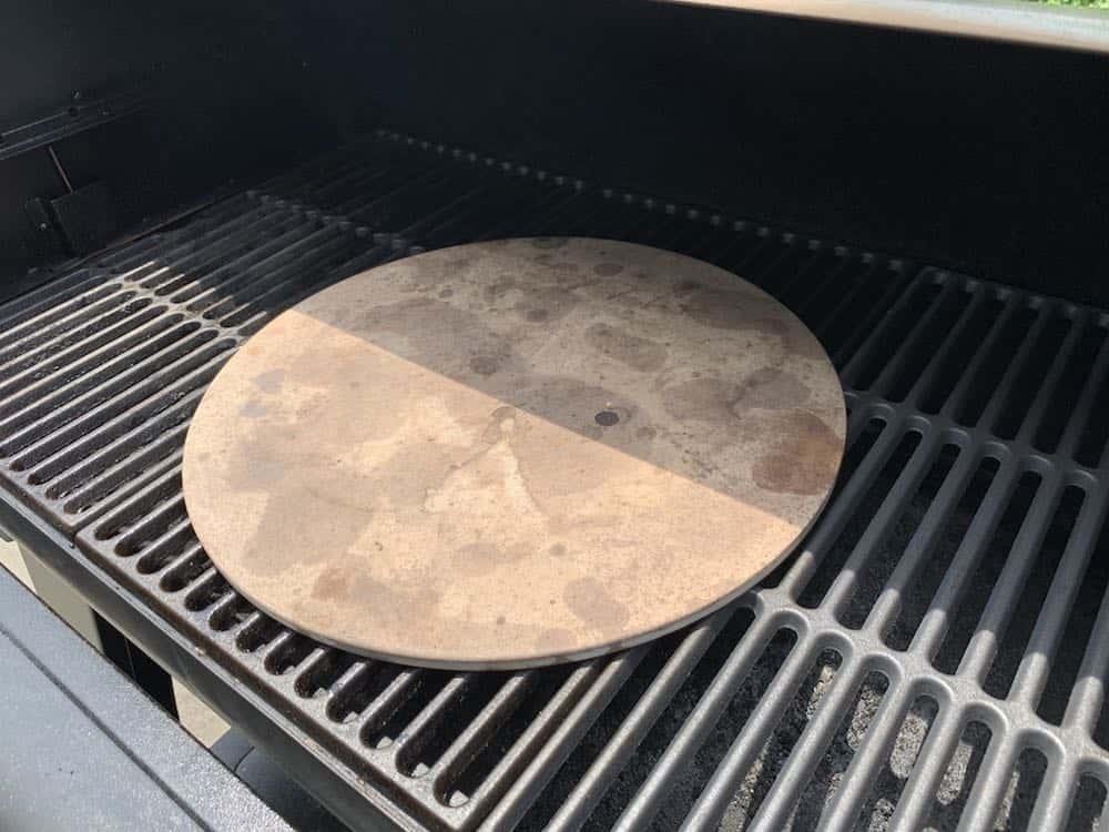 a pizza stone preheating on a pellet grill smoker